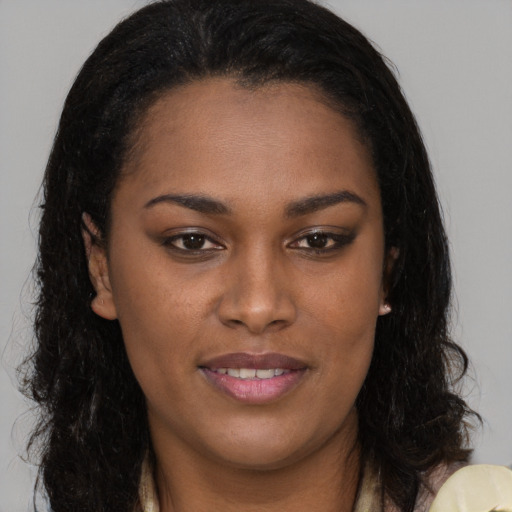 Joyful black young-adult female with long  brown hair and brown eyes