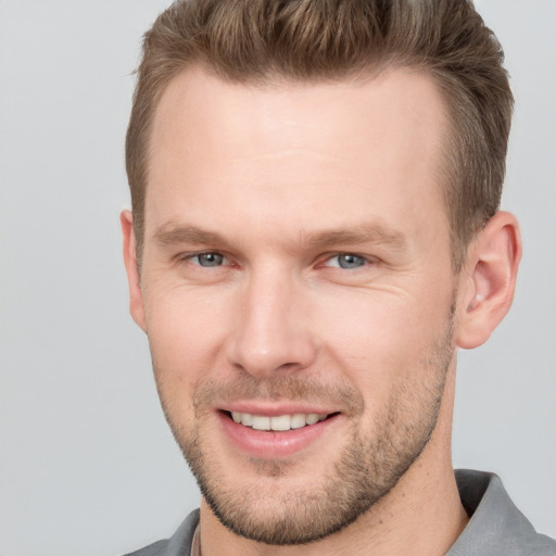 Joyful white adult male with short  brown hair and grey eyes