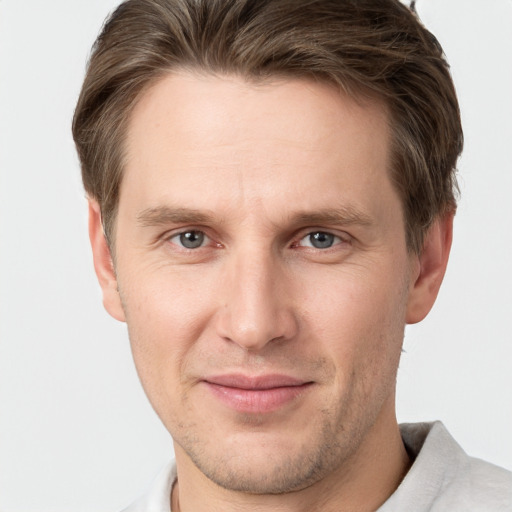 Joyful white young-adult male with short  brown hair and grey eyes