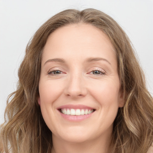 Joyful white young-adult female with long  brown hair and grey eyes