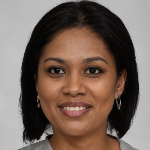 Joyful black adult female with medium  brown hair and brown eyes