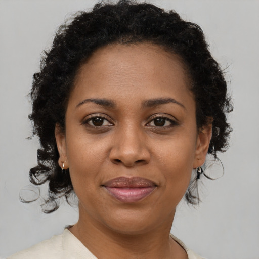 Joyful black adult female with short  brown hair and brown eyes