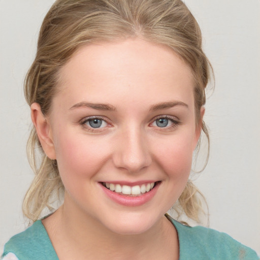 Joyful white young-adult female with medium  brown hair and blue eyes