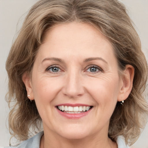 Joyful white adult female with medium  brown hair and grey eyes