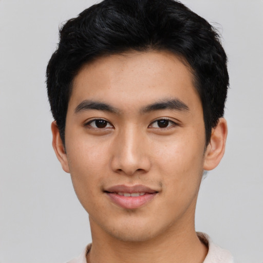 Joyful asian young-adult male with short  black hair and brown eyes