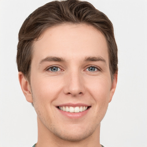 Joyful white young-adult male with short  brown hair and grey eyes