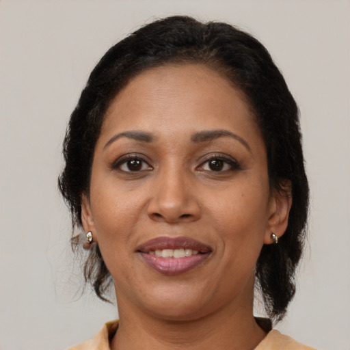 Joyful black adult female with medium  brown hair and brown eyes