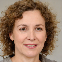 Joyful white adult female with medium  brown hair and blue eyes