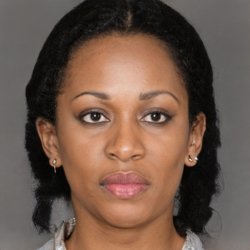 Joyful black young-adult female with long  black hair and brown eyes