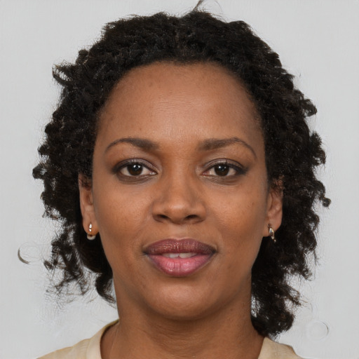 Joyful black adult female with medium  brown hair and brown eyes