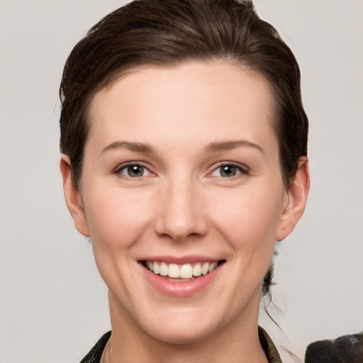 Joyful white young-adult female with short  brown hair and grey eyes