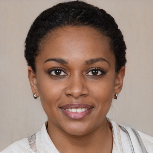 Joyful black young-adult female with short  black hair and brown eyes