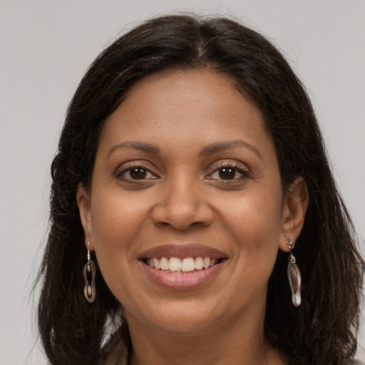 Joyful latino adult female with long  brown hair and brown eyes