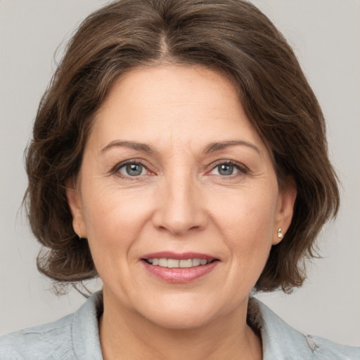 Joyful white adult female with medium  brown hair and grey eyes