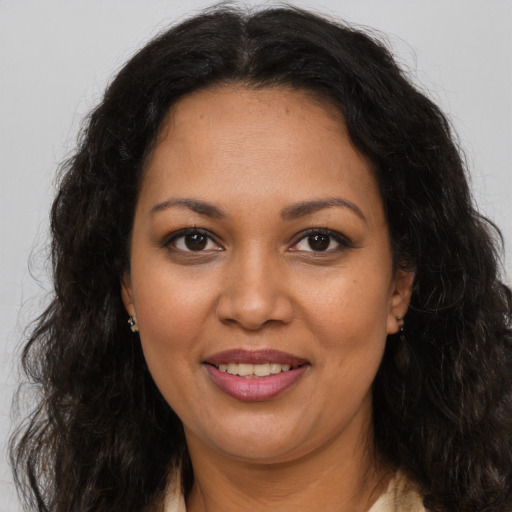 Joyful latino adult female with long  brown hair and brown eyes