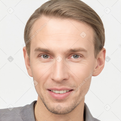 Joyful white young-adult male with short  brown hair and grey eyes