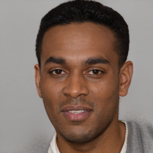 Joyful black young-adult male with short  brown hair and brown eyes