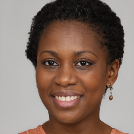 Joyful black young-adult female with short  brown hair and brown eyes
