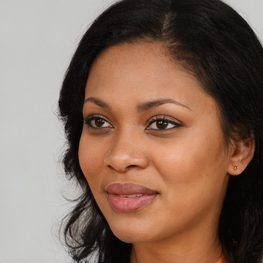 Joyful black young-adult female with long  black hair and brown eyes