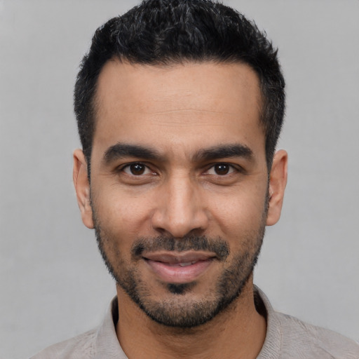 Joyful latino young-adult male with short  black hair and brown eyes