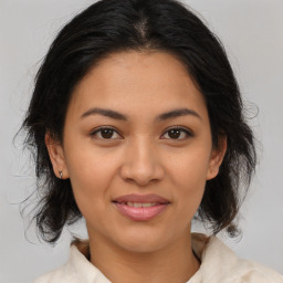 Joyful latino young-adult female with medium  brown hair and brown eyes