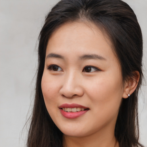 Joyful asian young-adult female with long  brown hair and brown eyes