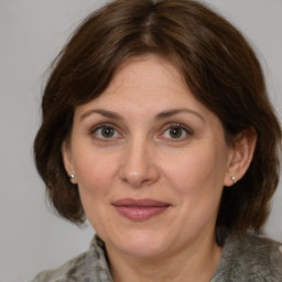 Joyful white adult female with medium  brown hair and grey eyes