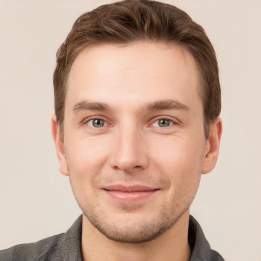 Joyful white young-adult male with short  brown hair and grey eyes