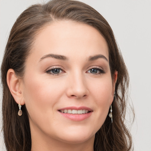 Joyful white young-adult female with long  brown hair and grey eyes