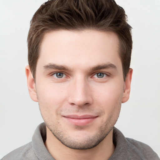 Joyful white young-adult male with short  brown hair and grey eyes