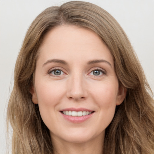 Joyful white young-adult female with long  brown hair and green eyes