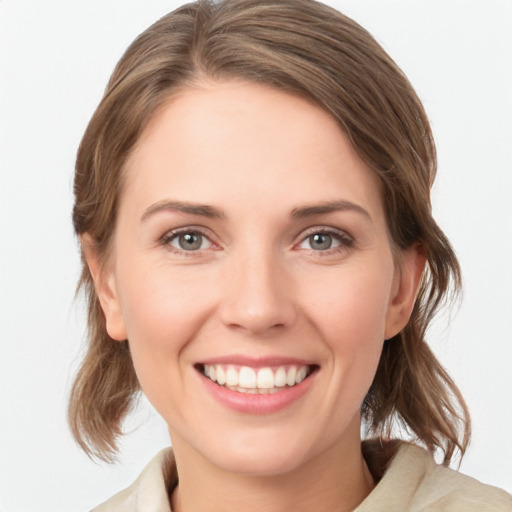 Joyful white young-adult female with medium  brown hair and green eyes