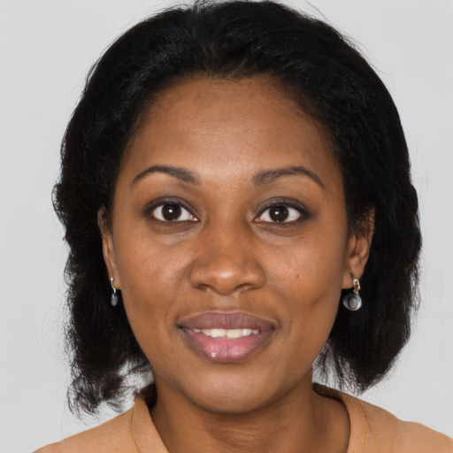 Joyful black adult female with medium  brown hair and brown eyes