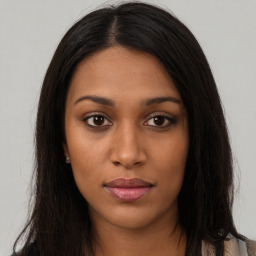 Joyful black young-adult female with long  brown hair and brown eyes