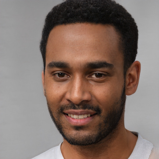 Joyful black young-adult male with short  black hair and brown eyes