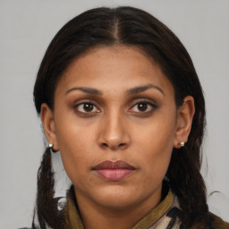 Joyful latino young-adult female with medium  brown hair and brown eyes