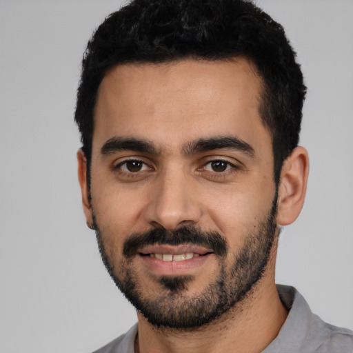 Joyful latino young-adult male with short  black hair and brown eyes