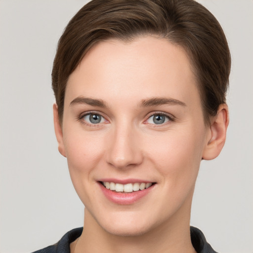 Joyful white young-adult female with short  brown hair and grey eyes