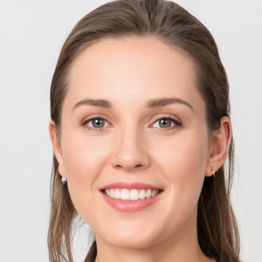 Joyful white young-adult female with long  brown hair and grey eyes