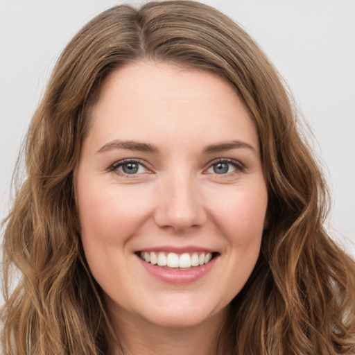 Joyful white young-adult female with long  brown hair and green eyes