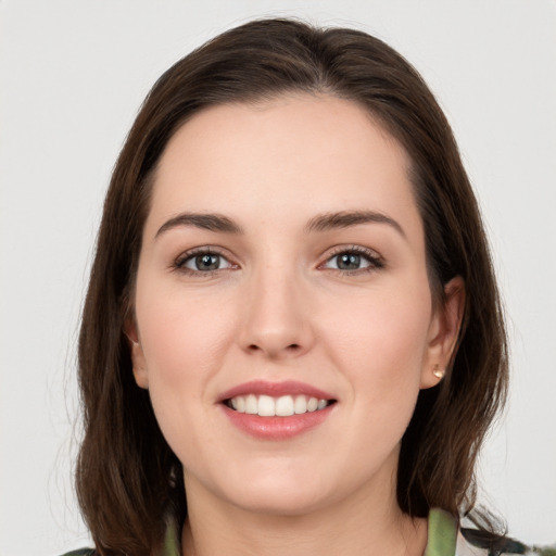 Joyful white young-adult female with long  brown hair and grey eyes