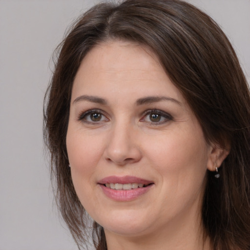 Joyful white adult female with medium  brown hair and brown eyes