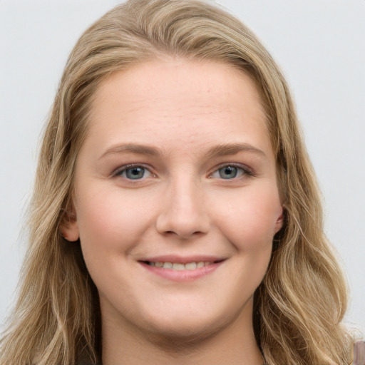 Joyful white young-adult female with long  brown hair and blue eyes