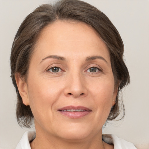 Joyful white adult female with medium  brown hair and brown eyes