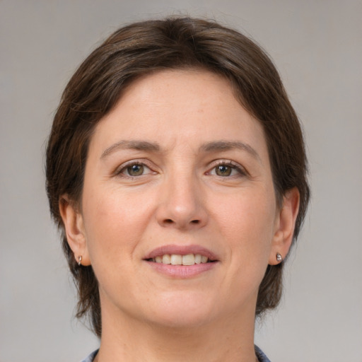 Joyful white adult female with medium  brown hair and grey eyes