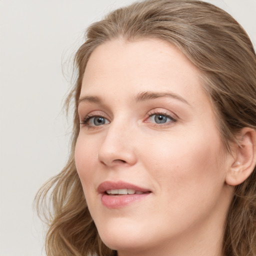 Joyful white young-adult female with long  brown hair and blue eyes