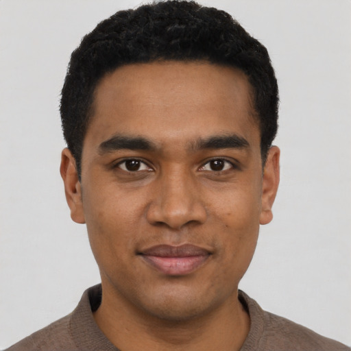 Joyful black young-adult male with short  black hair and brown eyes