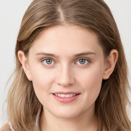 Joyful white young-adult female with long  brown hair and blue eyes