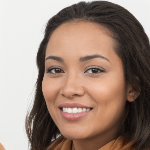 Joyful latino young-adult female with long  brown hair and brown eyes