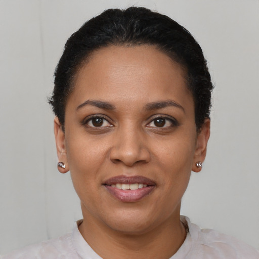 Joyful latino young-adult female with short  black hair and brown eyes